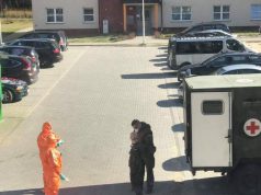 Wojskowa sanitarka z żołnierzami w kombinezonach ochronnych na lęborskim osiedlu / fot. Czytelnik