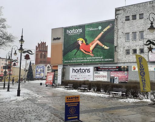 Wielki baner reklamowy w historycznym centrum Lęborka. Pytania o legalność na sesji Rady Miejskiej Reklama wielkoformatowa - Plac Pokoju w Lęborku
